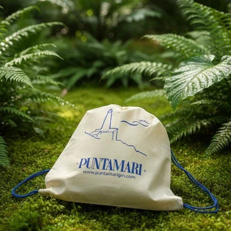 Sacca in fibra naturale Puntamari immersa nel verde, simbolo dell'impegno per un gin sostenibile italiano