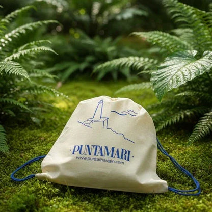 Sacca in fibra naturale Puntamari immersa nel verde, simbolo dell'impegno per un gin sostenibile italiano